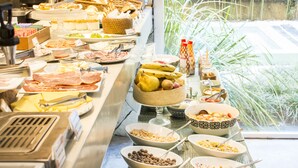 Un bufé con diversos alimentos y vista a la vegetación.