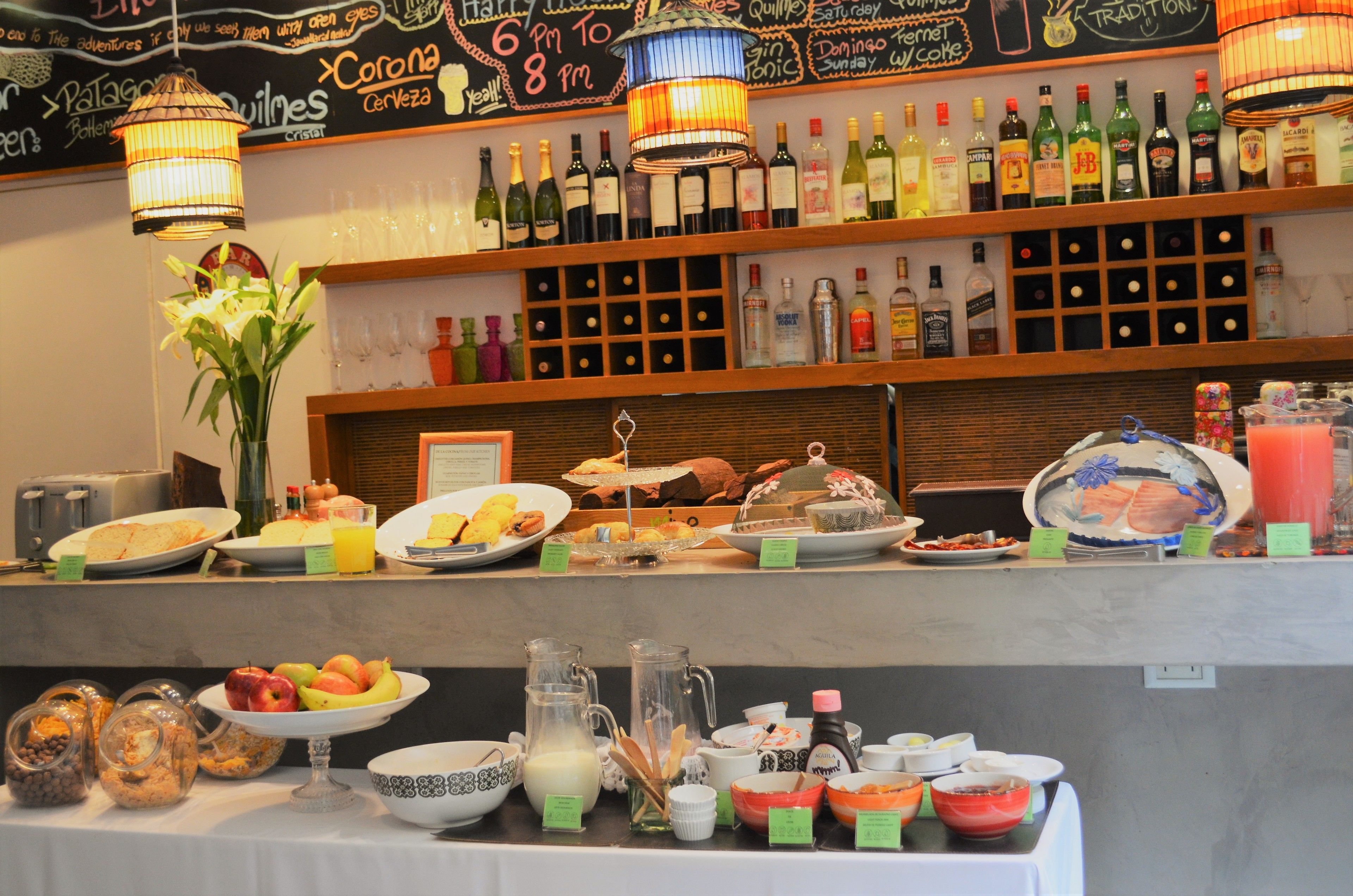 Un bufé de desayuno con diversas opciones de comida, bebidas y una selección de vinos a la vista.