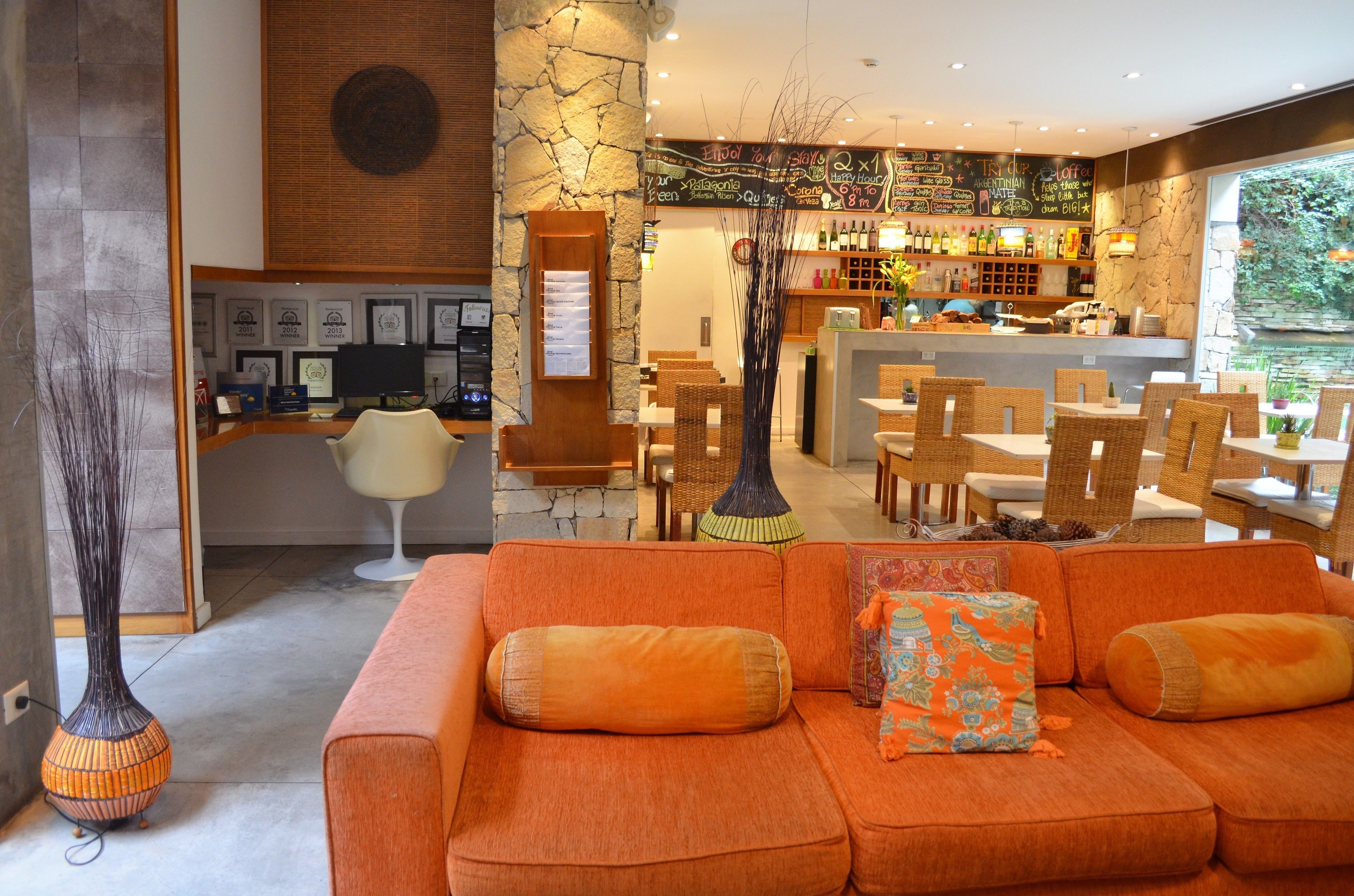 A modern interior with a bar area, seating, and a stone wall.