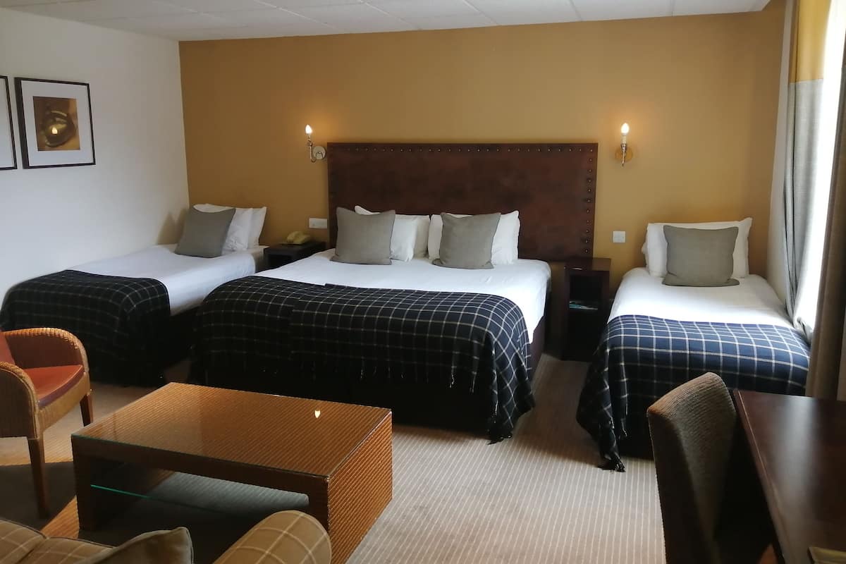 Ein Hotelzimmer mit zwei Betten, einem kleinen Tisch und einem Stuhl.