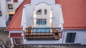 A modern building with a red-tiled roof, a balcony with a pool, and a sign for 'BRAA'. - Braavo Spa Hotel (Tallinn)