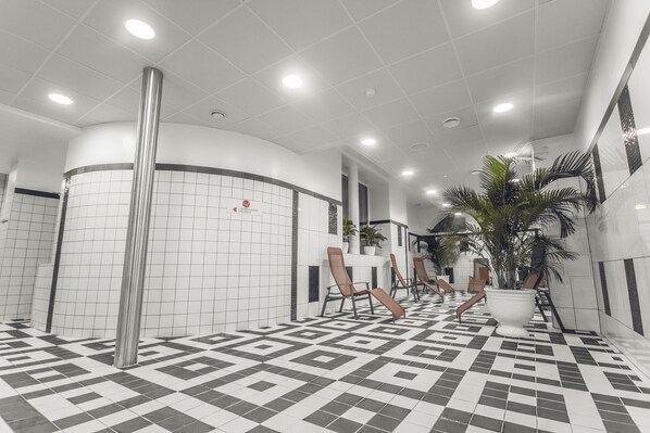 Un espacio interior moderno con suelo de cuadros, paredes blancas y una columna curva.