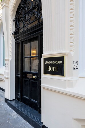 A black double door with a sign above it reading "Grand Concerto Hotel". - Grand Concerto Hotel (London)