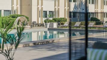 Una piscina al aire libre de temporada, sillones reclinables de piscina