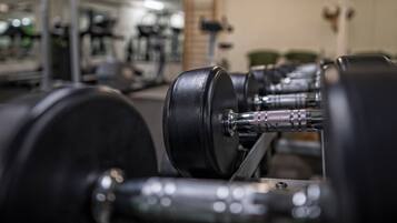 Un gimnasio con equipo de ejercicio, incluyendo pesas y una cinta de correr.