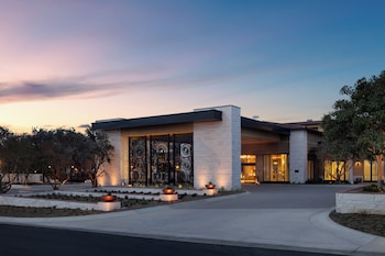 An outdoor patio with fire pits, wicker furniture, and hanging lights. at Hotel Solea, Autograph Collection