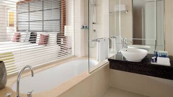 A modern bathroom with a glass-enclosed shower, a white bathtub, and a large mirror.