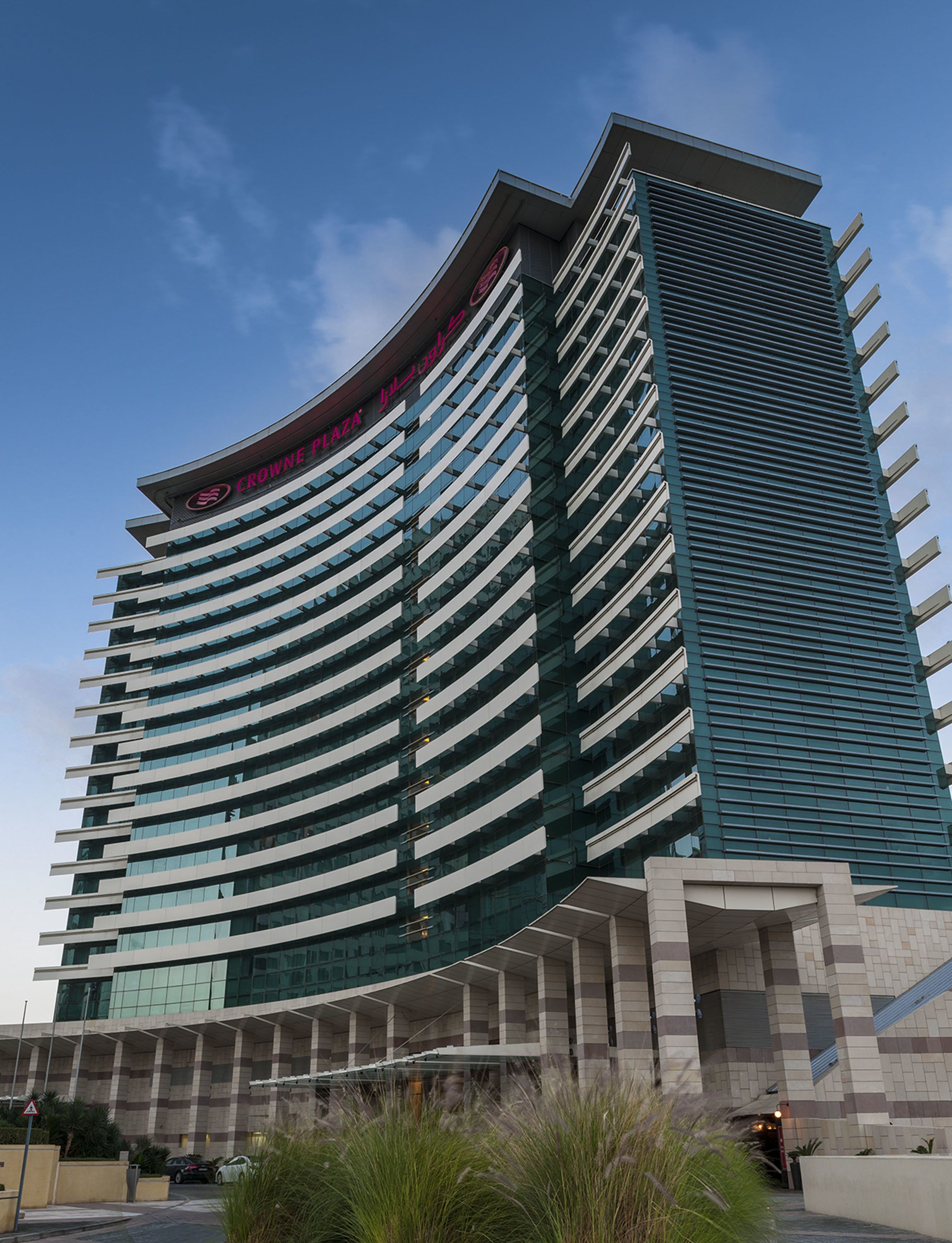 Un hotel moderno con fachada curva y varios balcones.