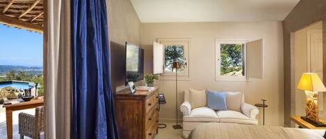 A bedroom with a bed, a desk, a chair, a dresser, and a view of a swimming pool.