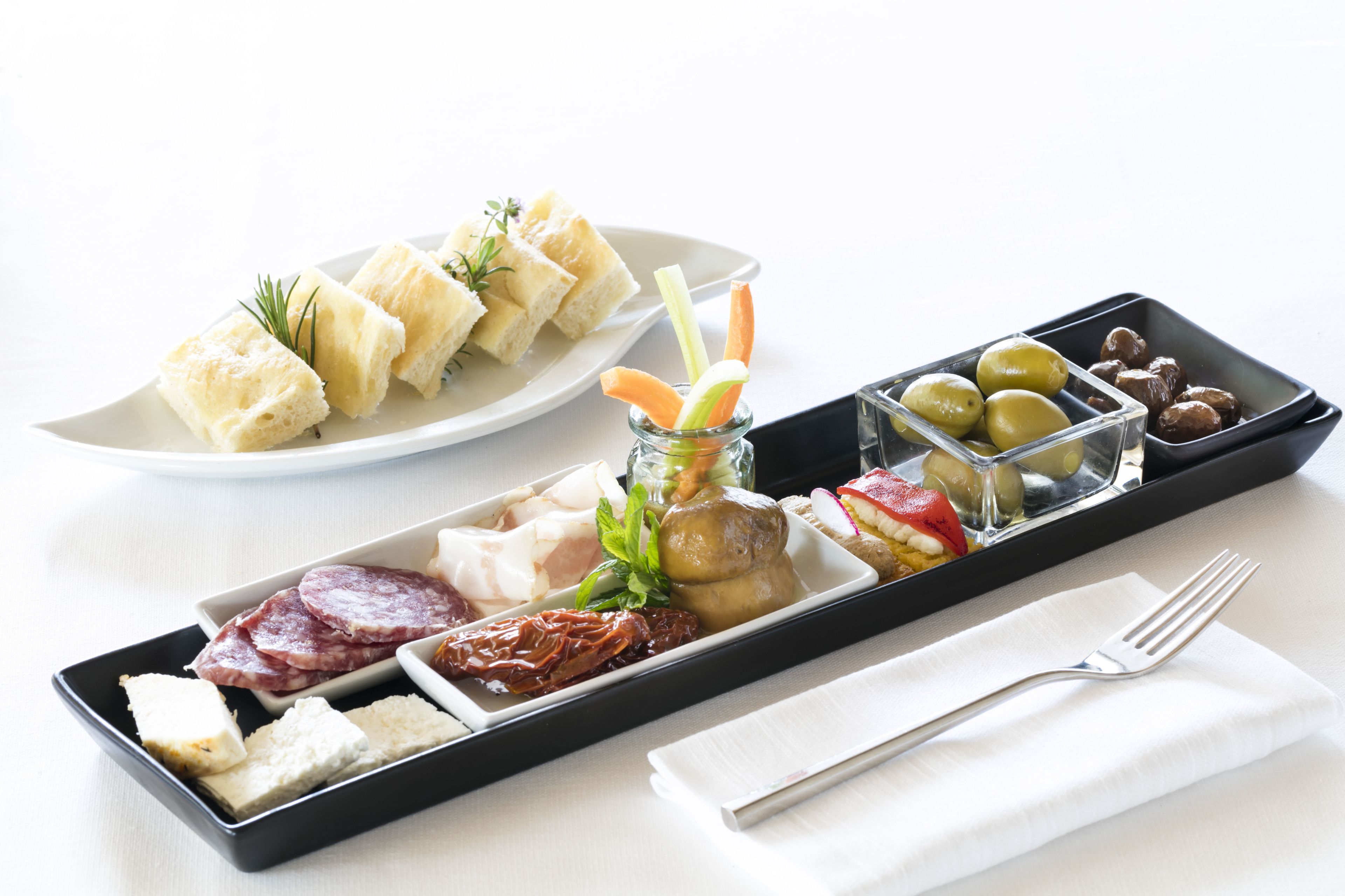 Un plateau garni d’un assortiment de fromages, de charcuteries, d’olives et de légumes marinés.