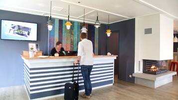 A reception desk with a striped design, a fireplace, and hanging pendant lights.