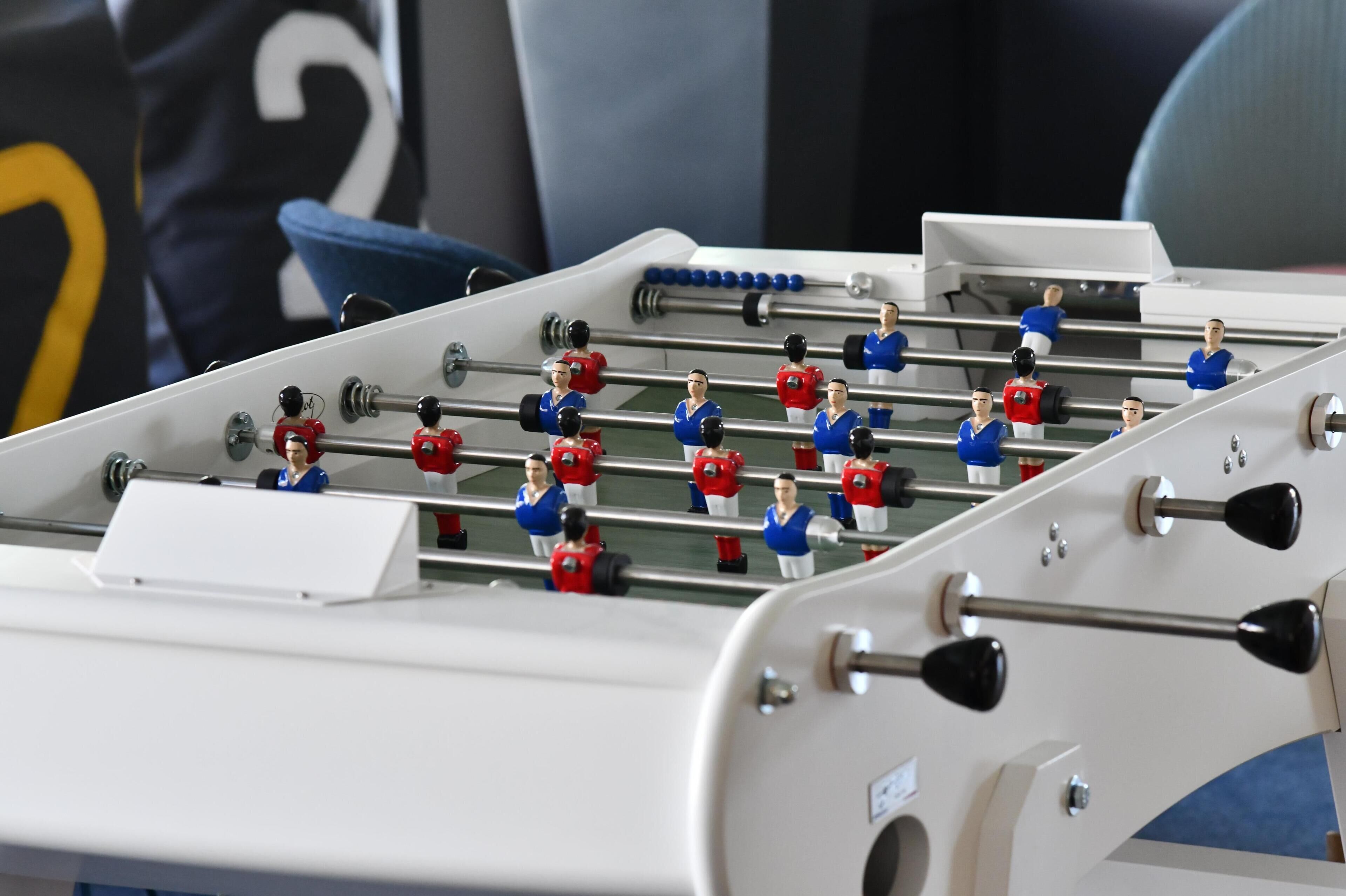 A foosball table with players in red and blue uniforms.