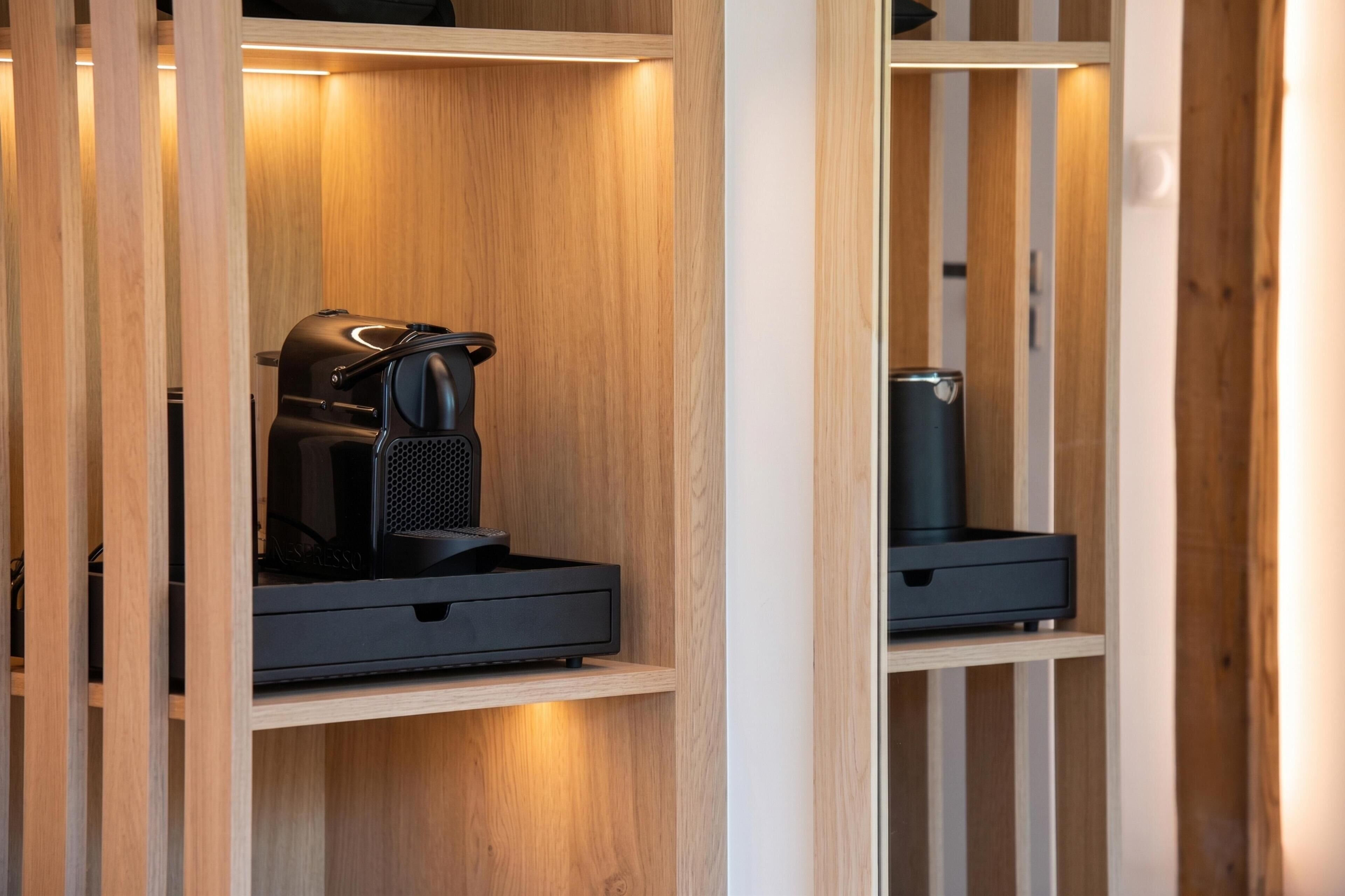 Un armario de madera con una cafetera y un recipiente.