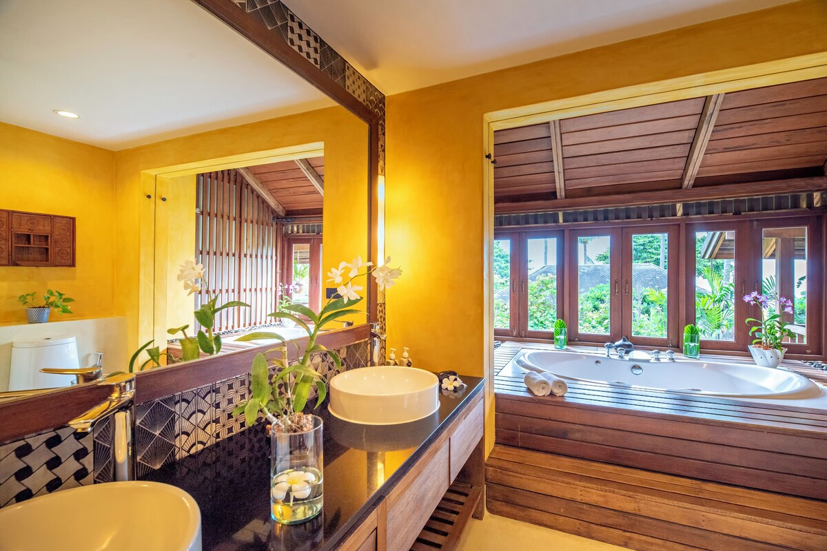 A bathroom with two sinks, a large mirror, and a bathtub.