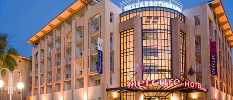 A hotel with a prominent sign for 'Mercure Hotel' and 'ThalassoTherapie' on the facade.