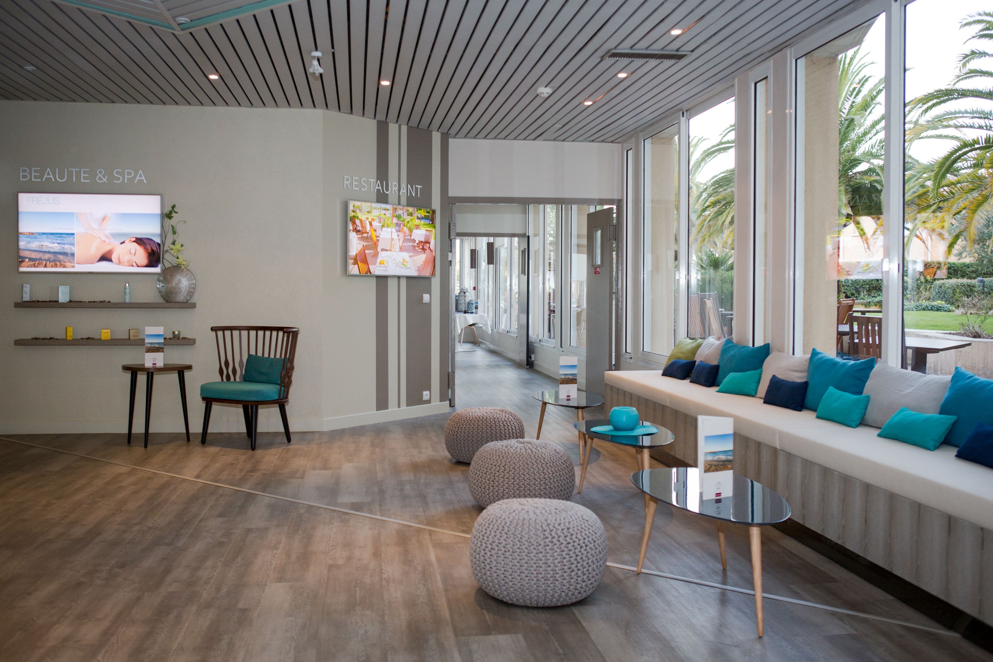 Un espace comprenant un spa et un restaurant, doté d’un plancher en bois, de différents types de sièges et de grandes fenêtres offrant une vue sur l’extérieur.