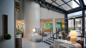 Eine großzügige Lobby mit Treppe, Empfangstresen und modernem Design.