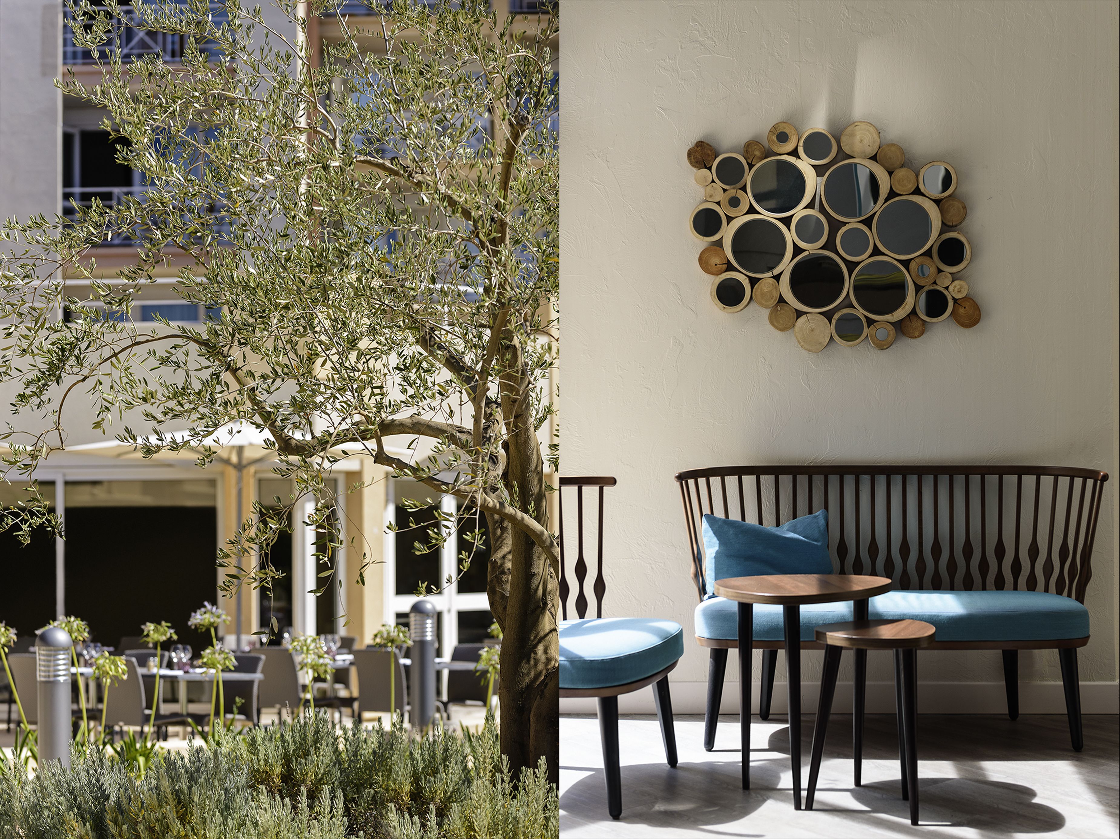 An outdoor seating area with a round table and a sofa, and a wall with a circular mirror arrangement.