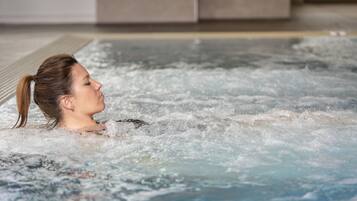 A person in a hot tub with visible bubbles and water.