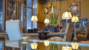 A well-lit, elegantly furnished lounge area with a reflective floor, plush seating, and decorative lamps. - MGM MACAU (Macau)