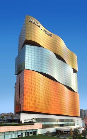 A multi-story building with a distinctive architectural design, featuring a mix of reflective and matte surfaces. - MGM MACAU (Macau)