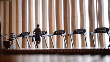 A gym with treadmills and a person using one.