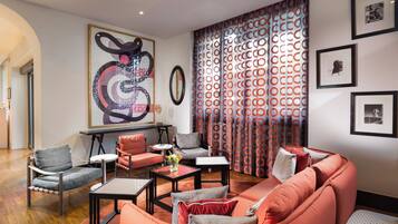 A modern living room with a sofa, chairs, a coffee table, and artwork on the walls.
