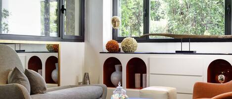 Un salon moderne comprenant un canapé, des fauteuils, une table basse et une bibliothèque.