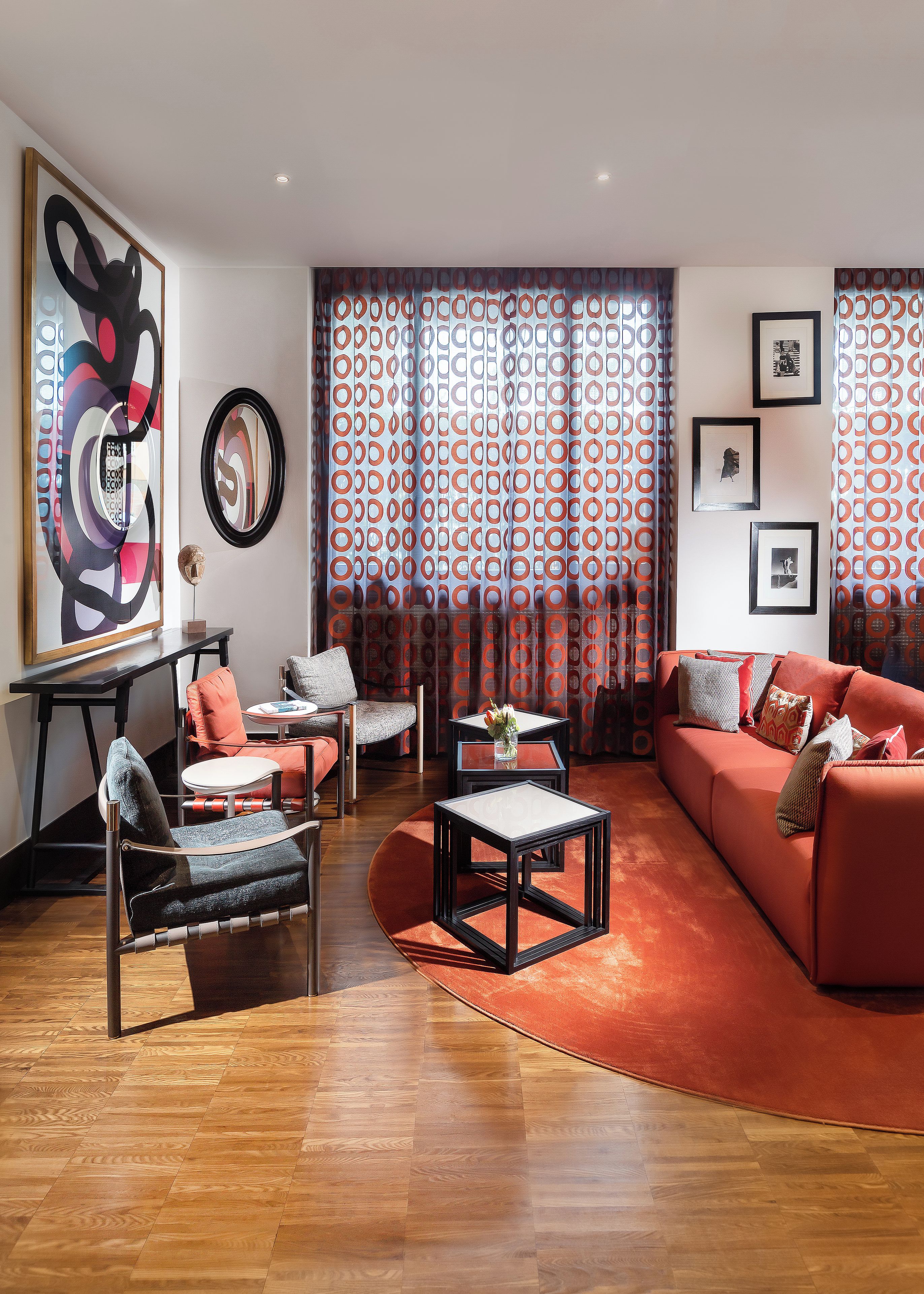 A modern living room with a sofa, chairs, a coffee table, and artwork on the walls.
