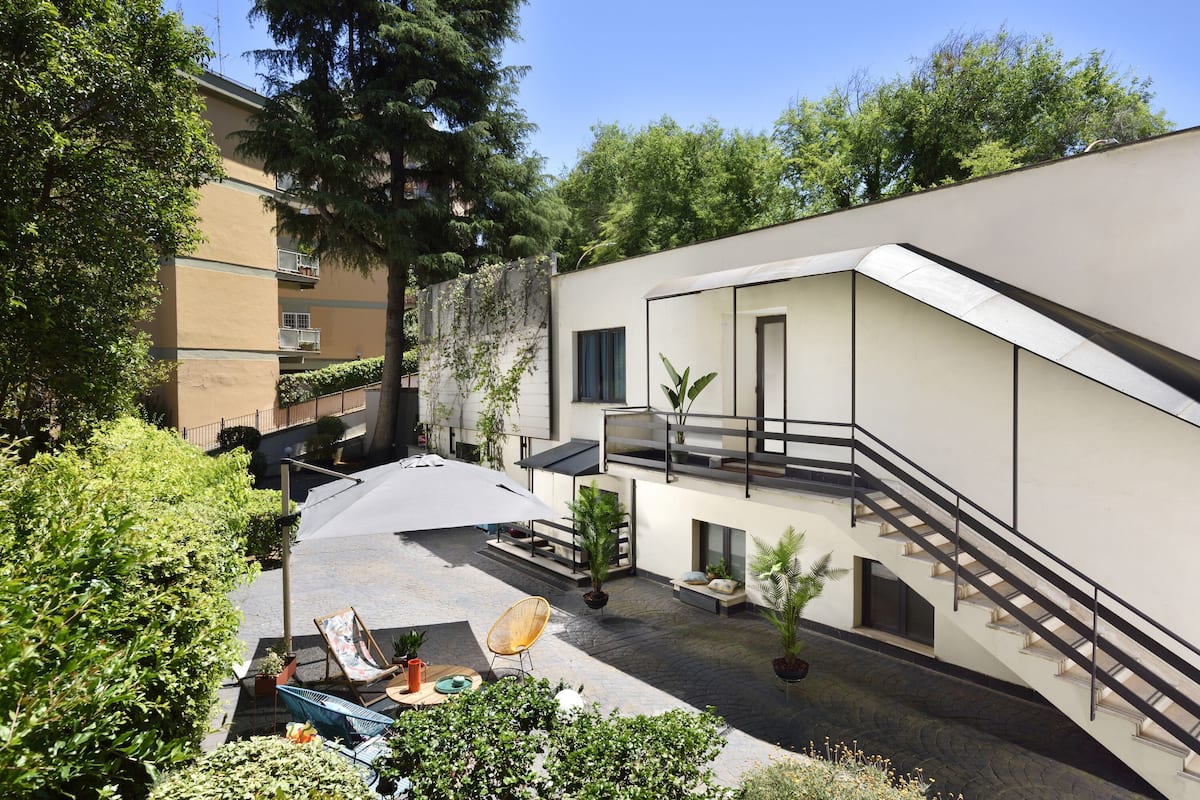 A modern building with a courtyard, outdoor seating, and a staircase.