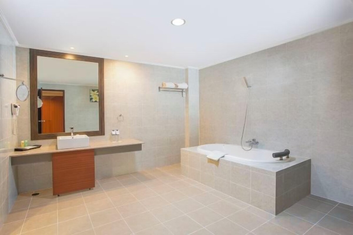 Une salle de bain moderne avec une baignoire, un meuble-lavabo avec un miroir et une douche.