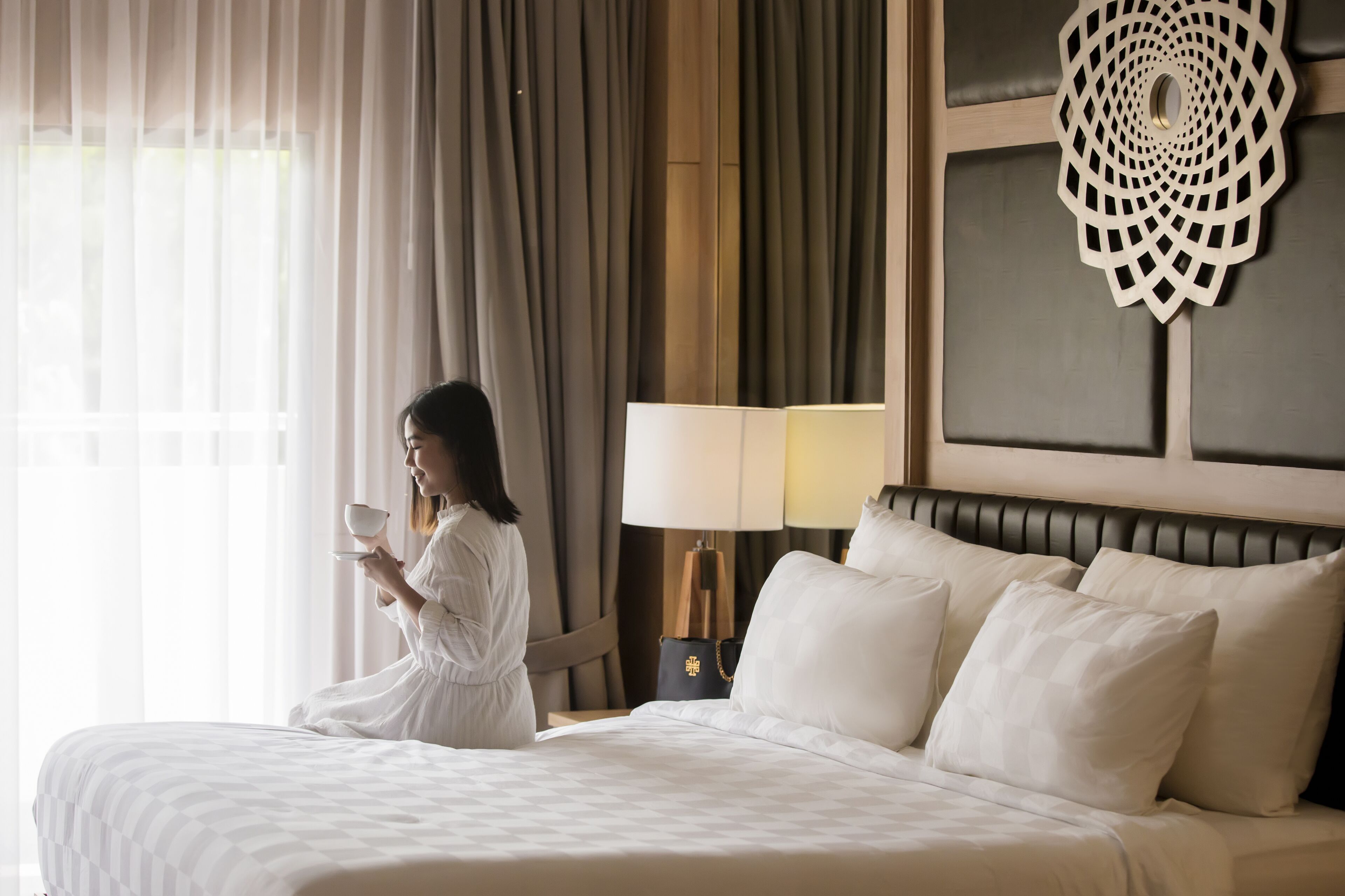 Une chambre d’hôtel avec un grand lit, une table de chevet avec une lampe et un élément décoratif mural.