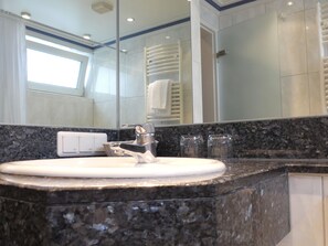 A bathroom with a granite countertop, a white sink, a chrome faucet, and a mirror. - Appartel am Dom (Cologne)