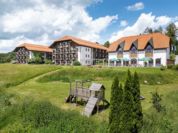 Un hôtel composé de plusieurs bâtiments, doté d’une terrasse et d’un espace de jeux pour enfants.