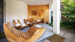 A spa area with wooden loungers, a sauna, and a stone floor.