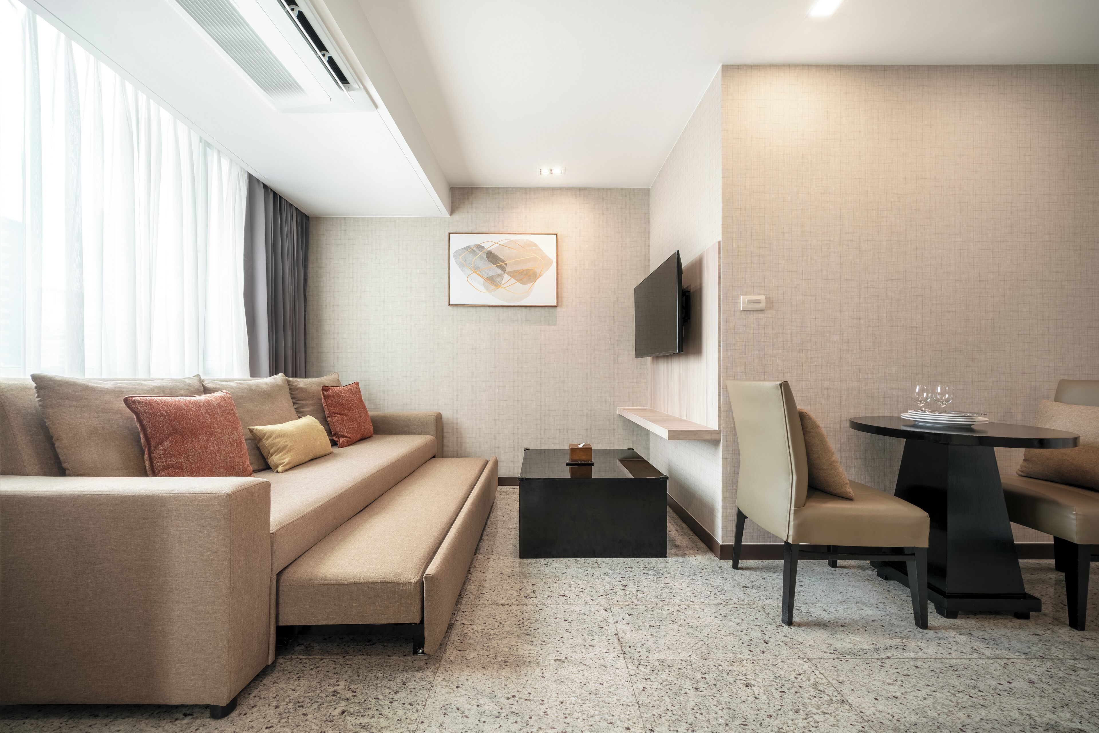 A modern living room with a sofa, coffee table, and dining area.