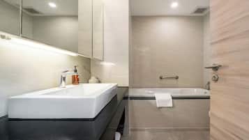 A modern bathroom with a large sink, a mirror, a shower, and a bathtub.