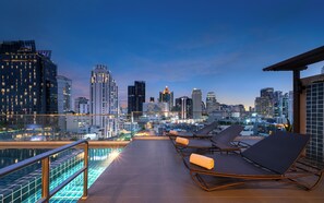 Alberca al aire libre y camastros