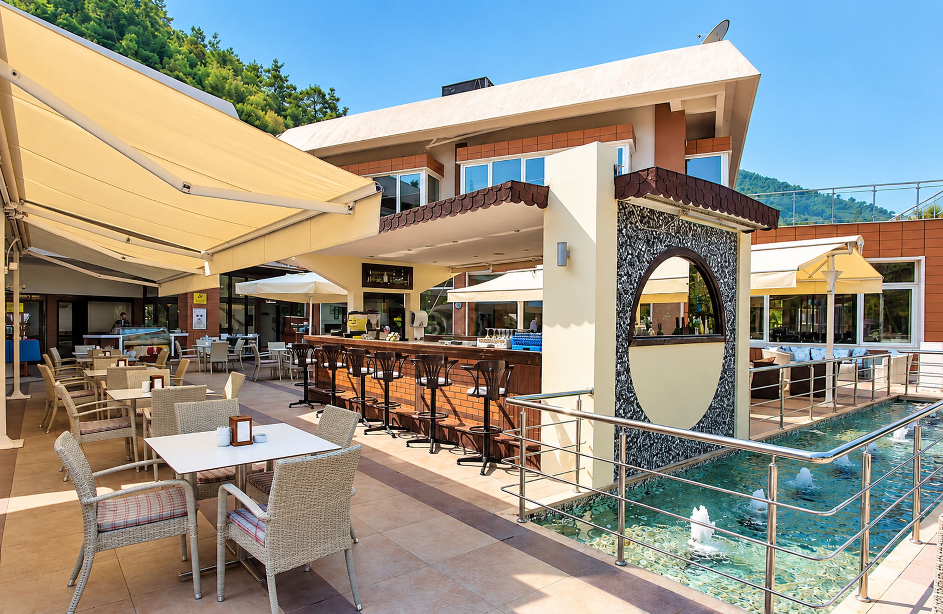 Un área de bar al aire libre con asientos, una piscina y vistas a la montaña.