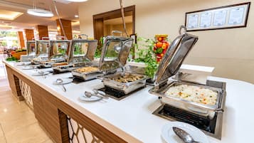 Disposición de bufé con múltiples estaciones de autoservicio, que incluyen diversas opciones de comida y utensilios.