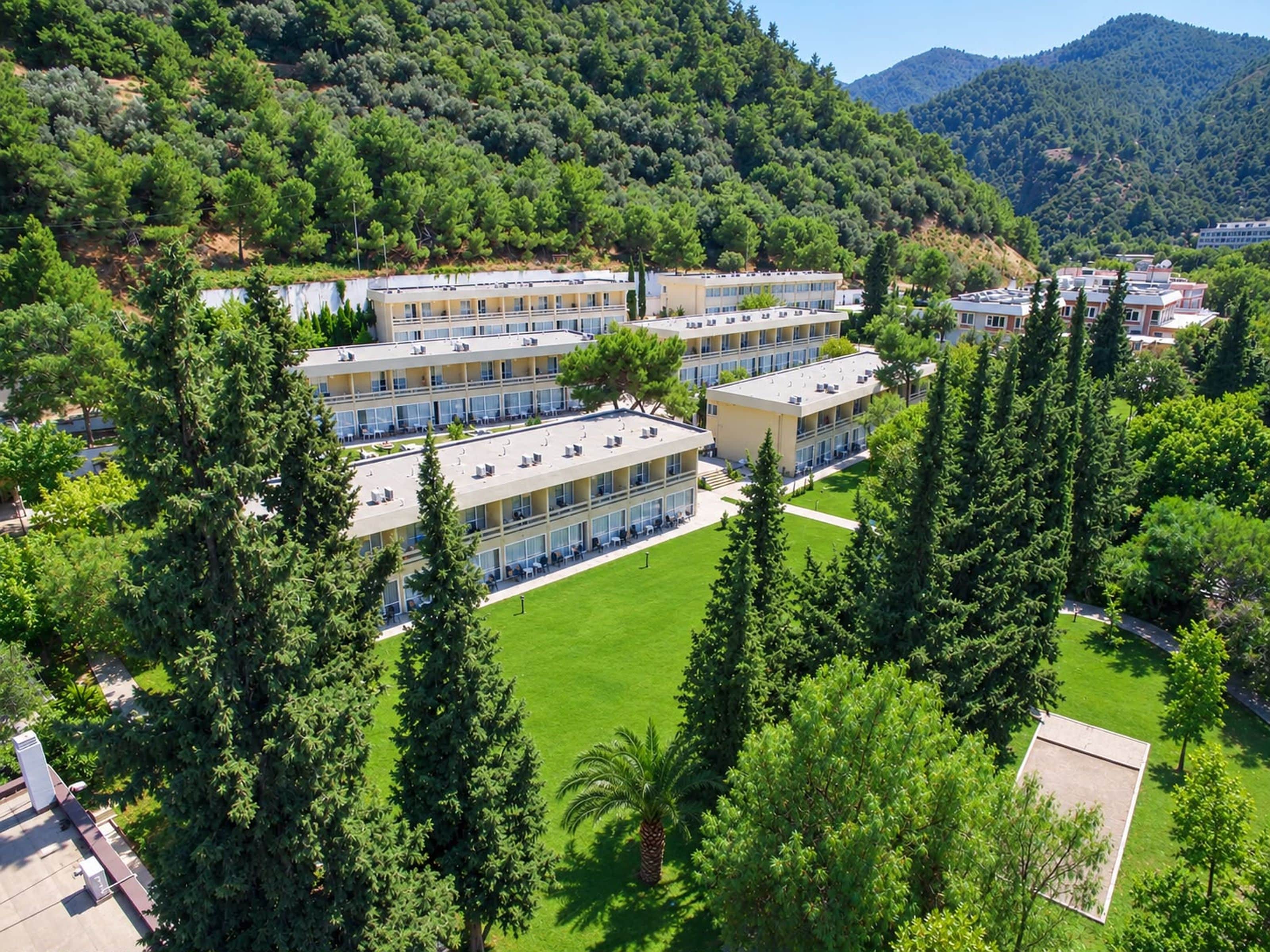 A multi-story hotel with a central courtyard surrounded by trees.