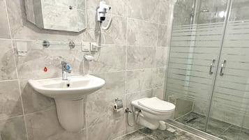 Ein Badezimmer mit Marmorwaschbecken, Toilette und einer Duschkabine.