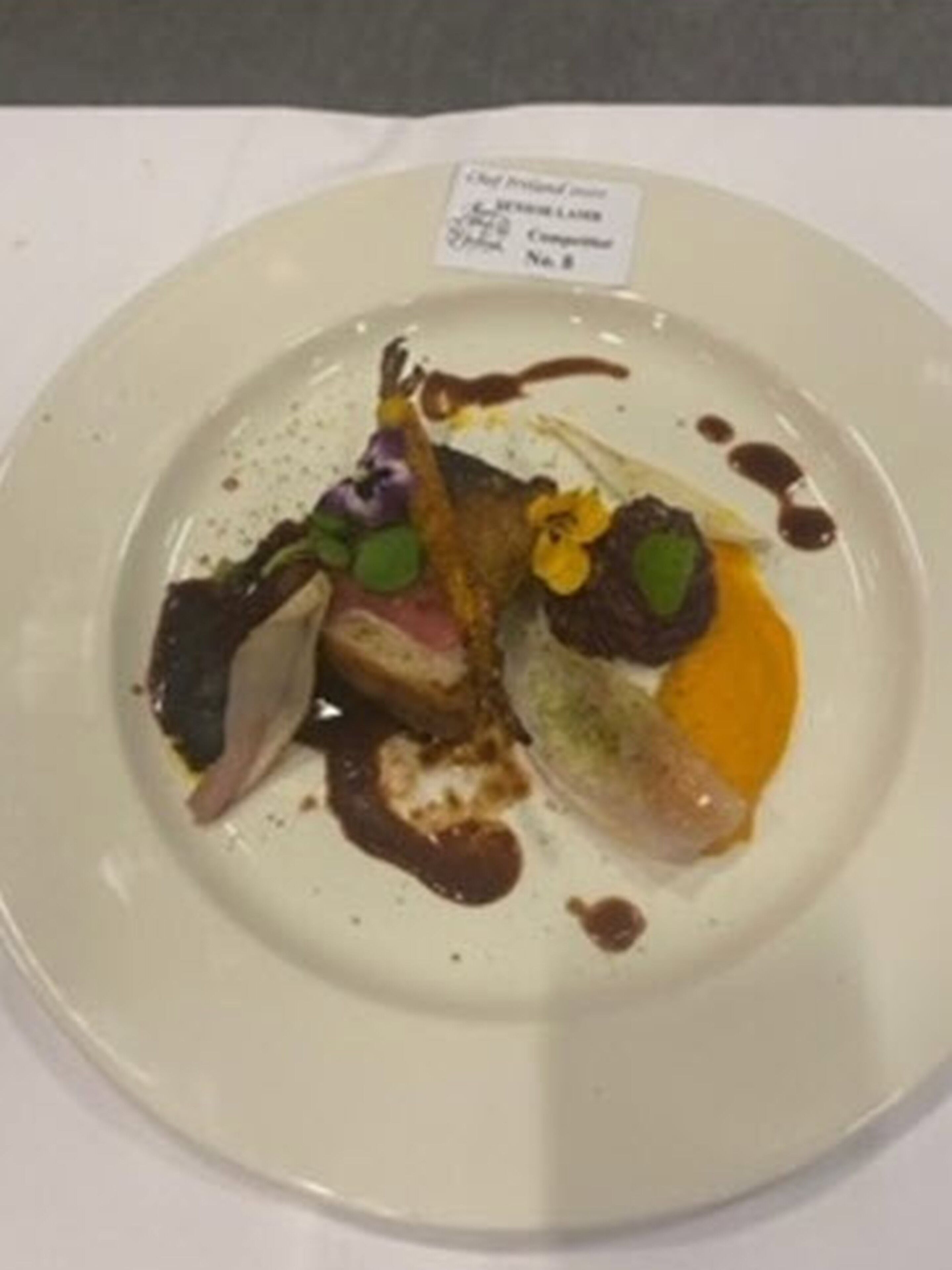 Een bord met verschillende soorten eten en een klein label.
