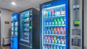 Tres máquinas expendedoras con la marca Pepsi, una pantalla digital y un teclado.