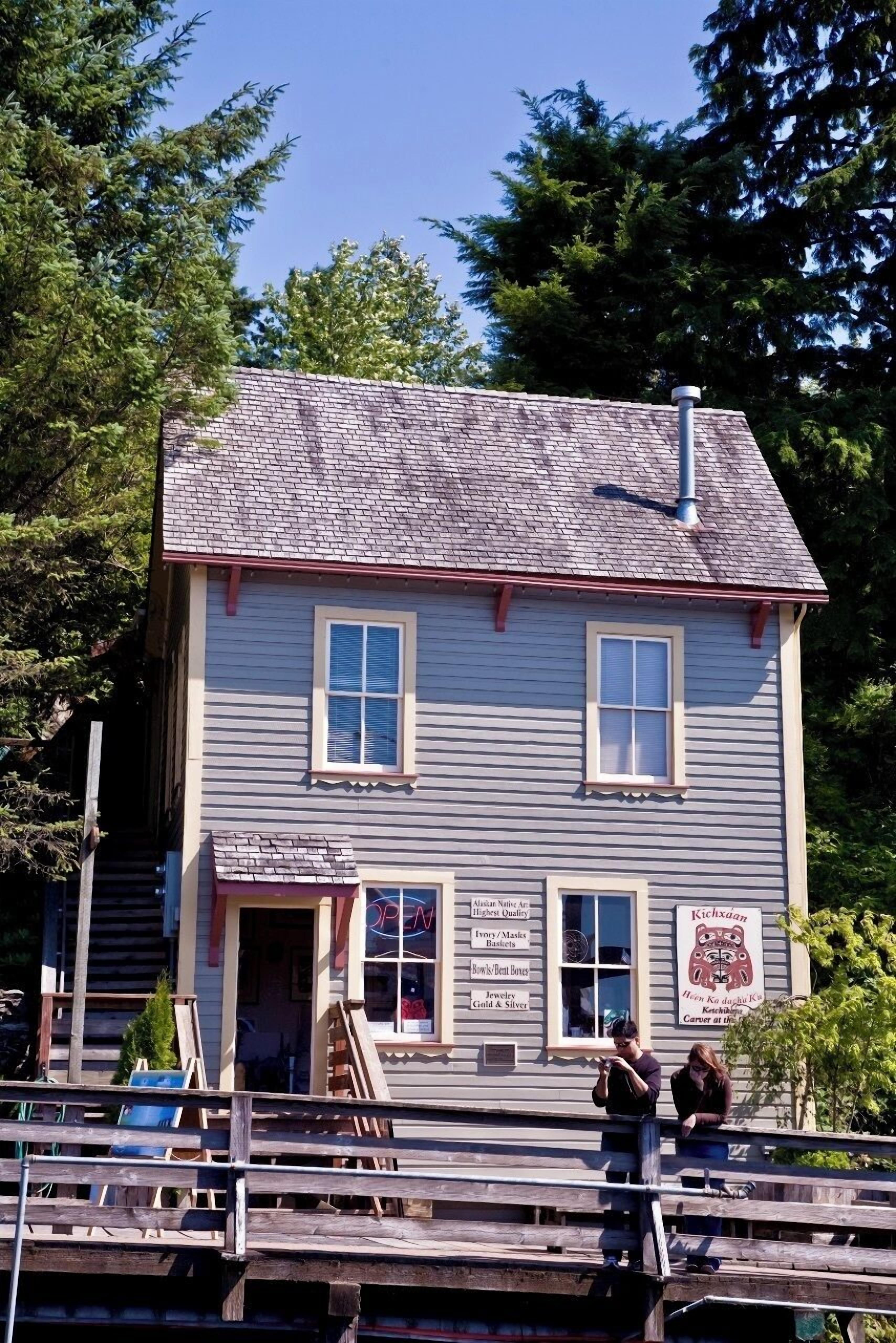 Un bâtiment à deux étages, sur lequel est apposée une enseigne publicitaire présentant divers articles en vente.