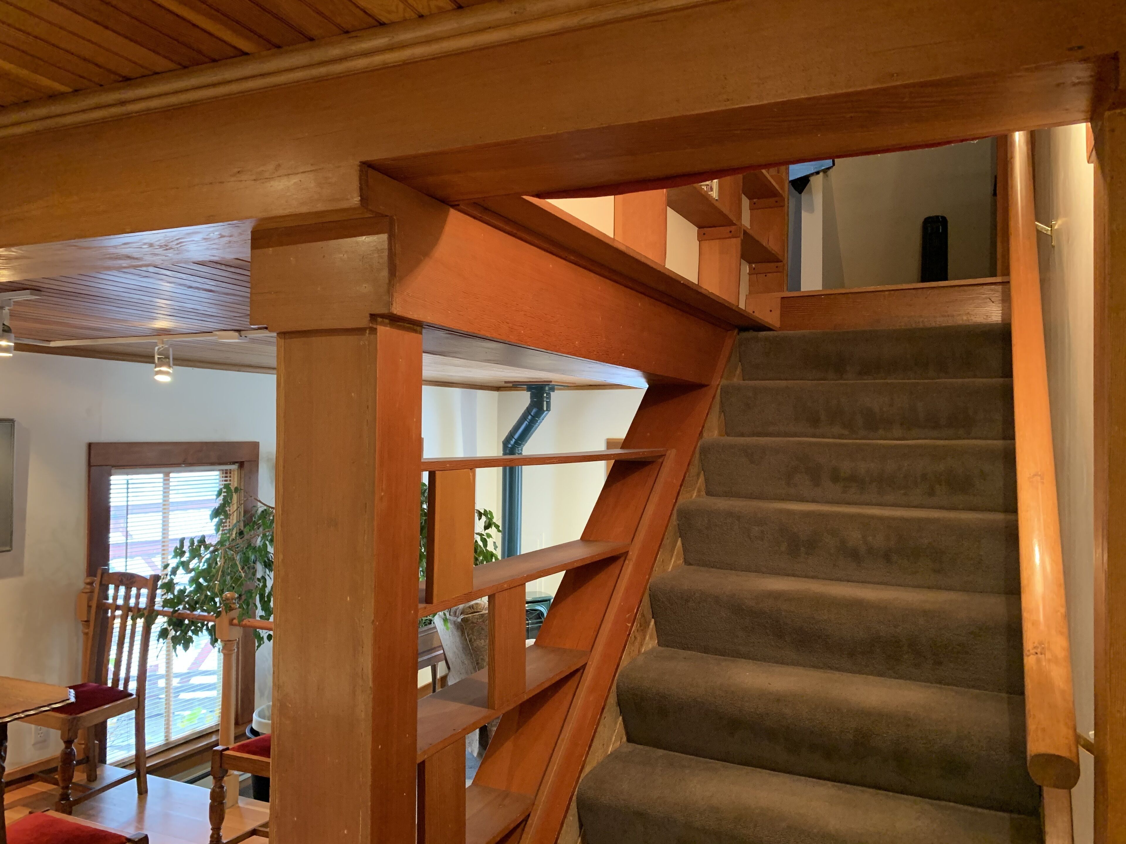 A wooden staircase with a carpeted landing.