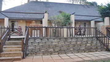 A building with a thatched roof, stone steps, and a wooden fence.