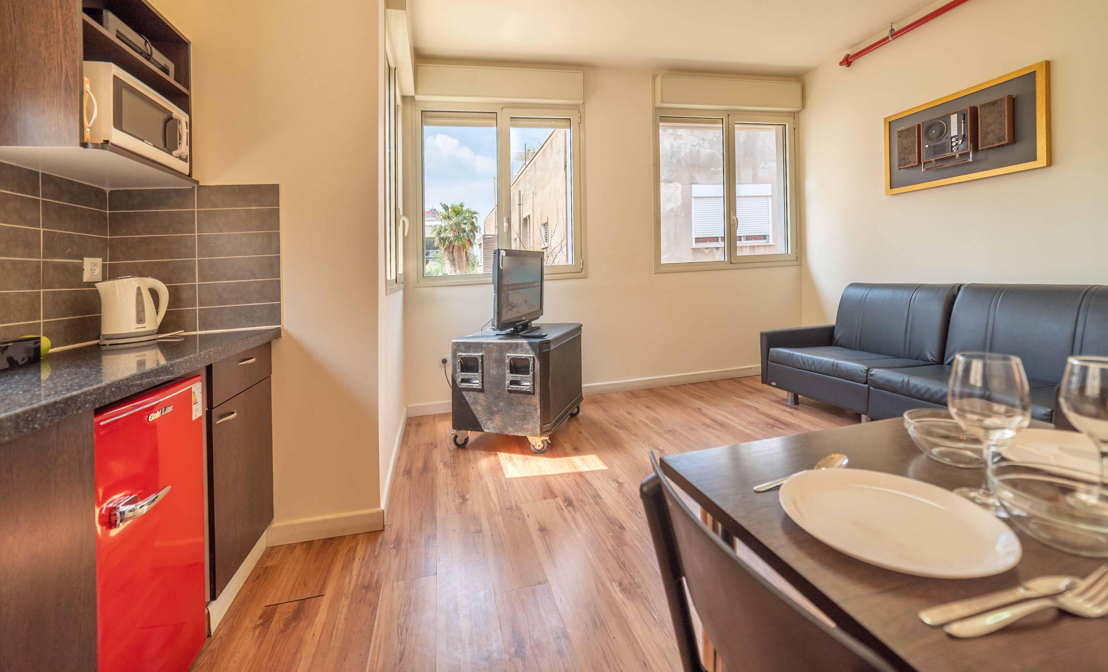 A compact living space with a kitchenette, a sofa, and a dining area.