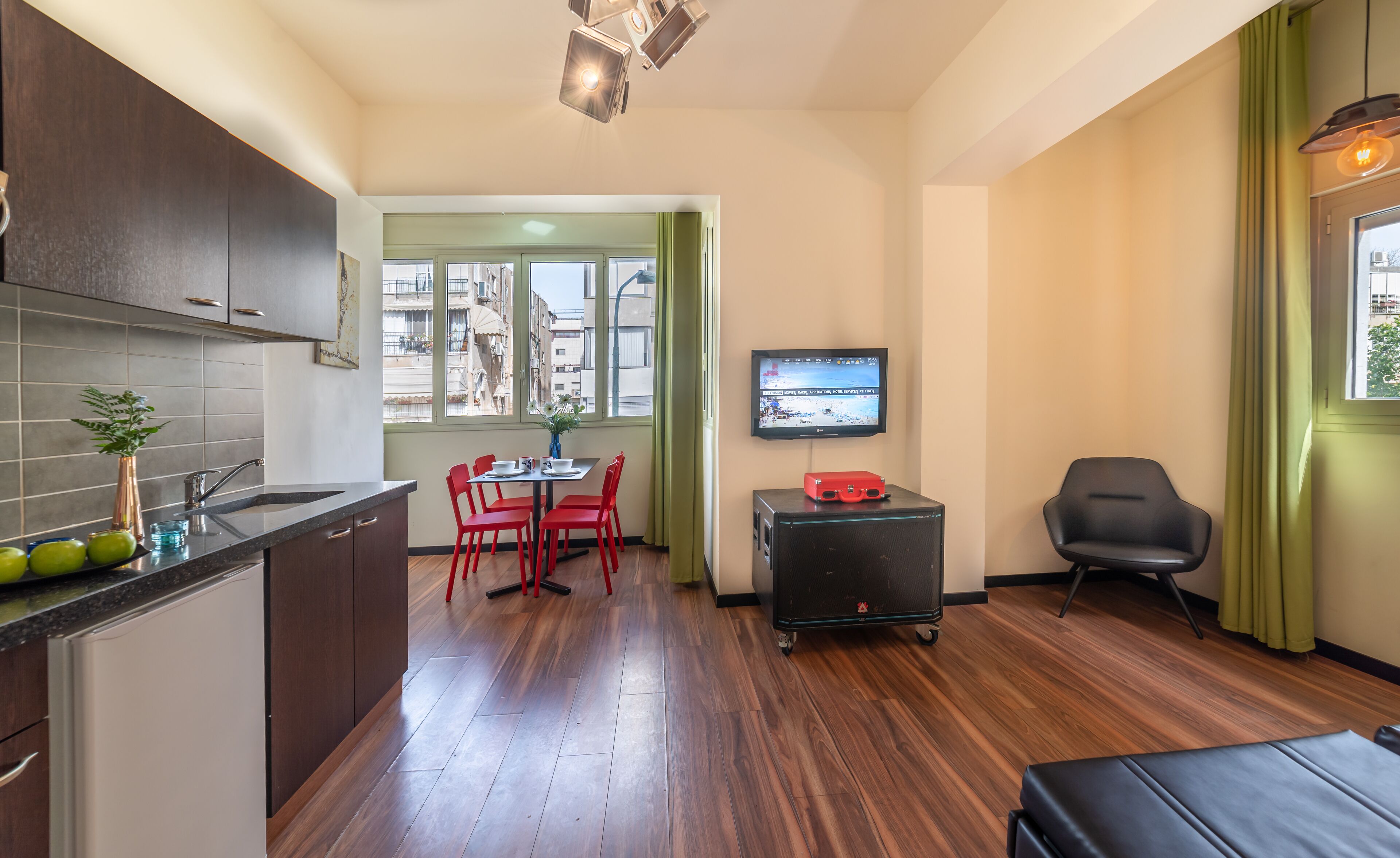 A compact living space with a kitchenette, dining area, and seating.