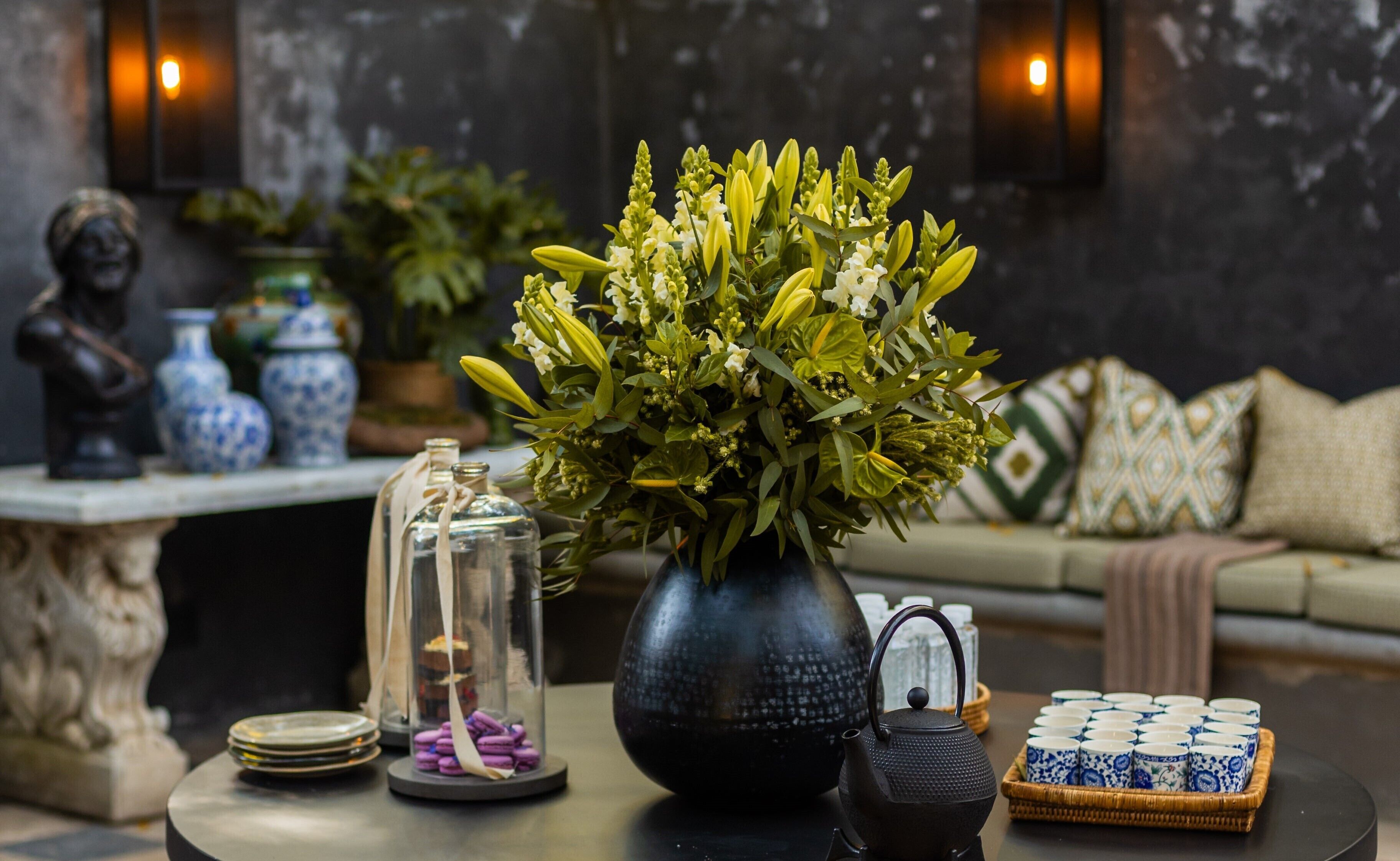Una sala de estar con un florero, una tetera y una bandeja de tazas de té.